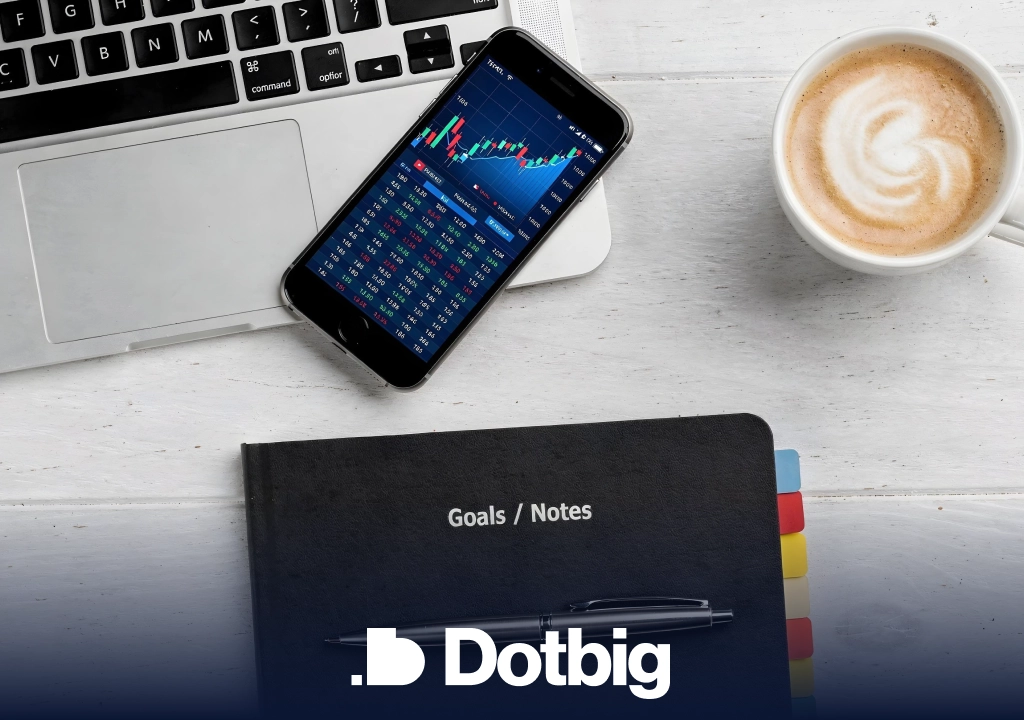 Dotbig – Смартфон с графиком торгов и ноутбук на рабочем столе трейдера